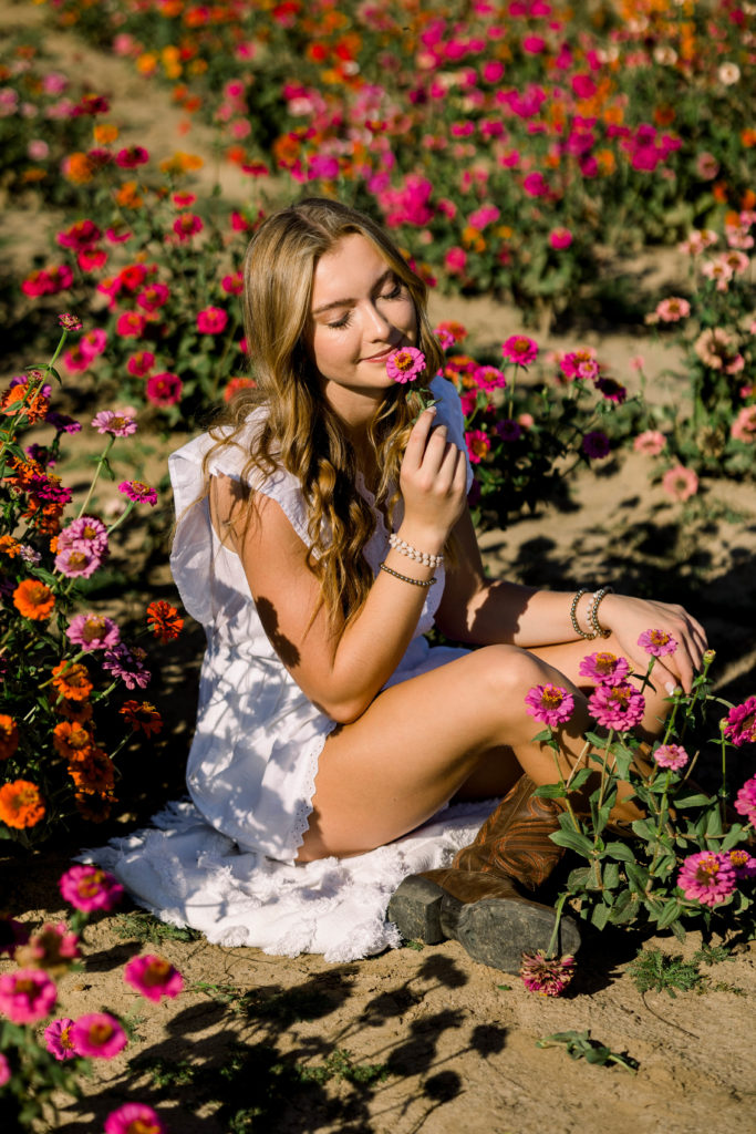 Senior girl sitting in wildflowers at Holland Farms