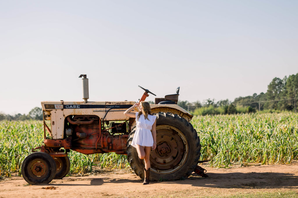 Girl posing on a tractor at a farm