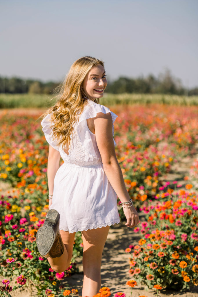 Girl running with wildflowers at senior session