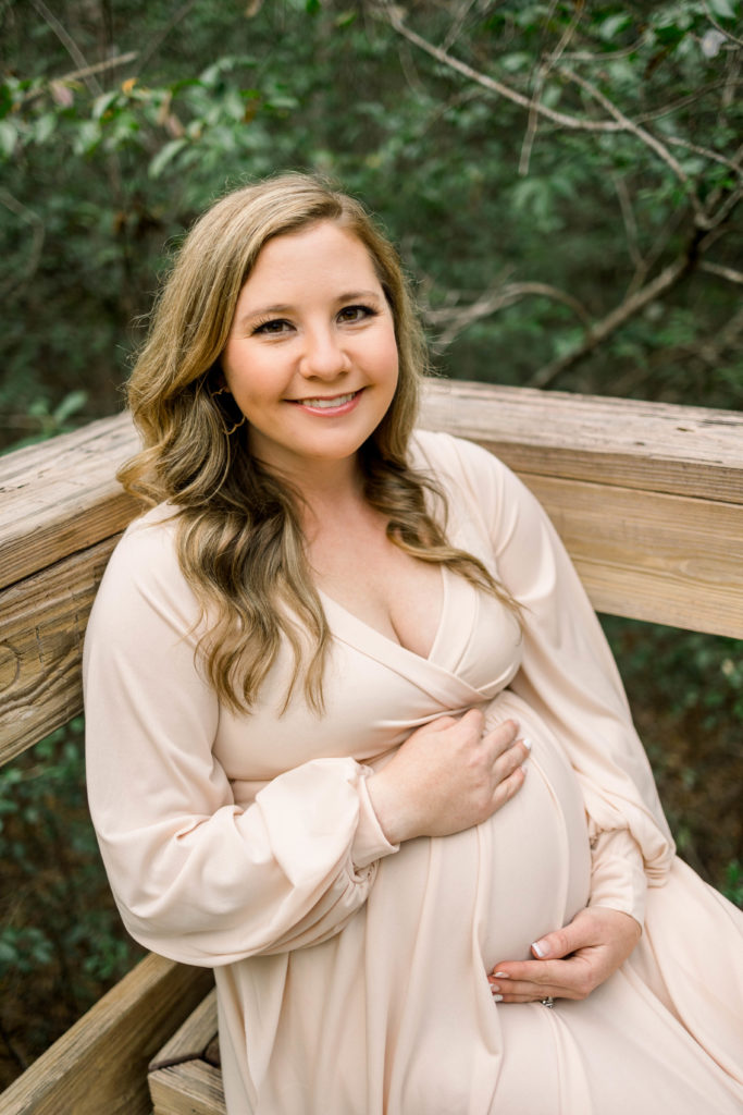 Pregnant woman posing holding belly at maternity photo