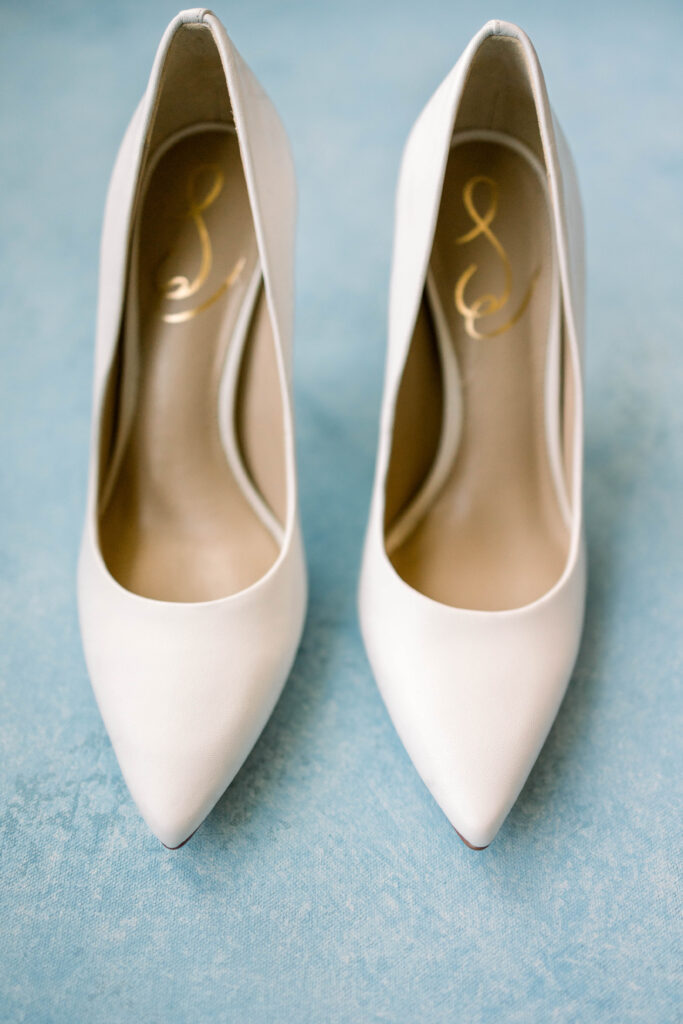 Pair of white high heels on a blue mat at a Scenic Hills Country Club Wedding
