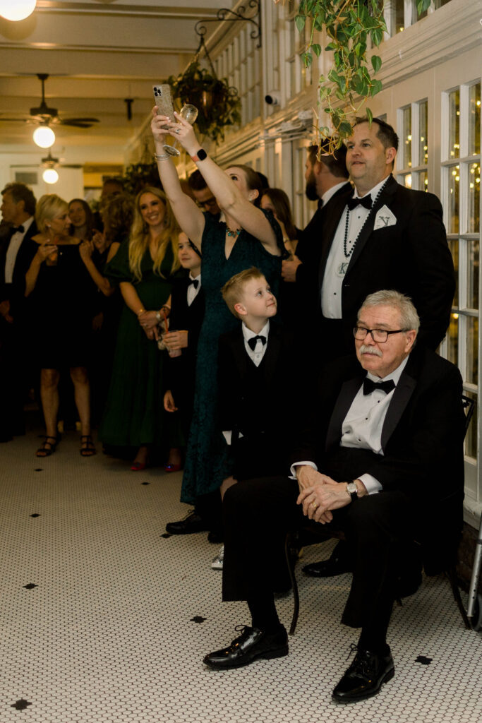 Father of the groom watching the mother and son dance
