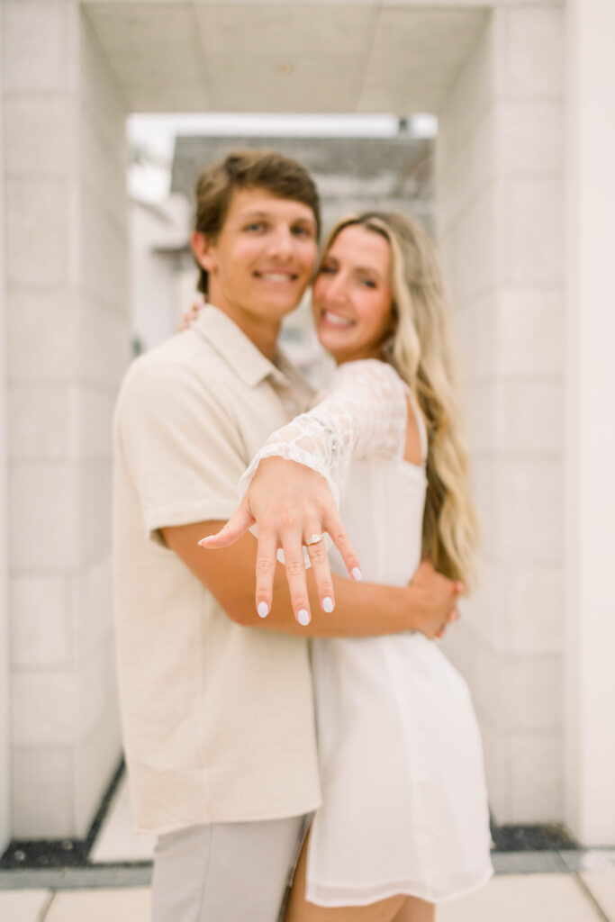 Engaged couple showing their engagement ring at Kaiya Beach Photoshoot 