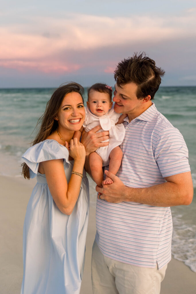 Mom, Dad, and baby posing on the beach in Watersound 30A