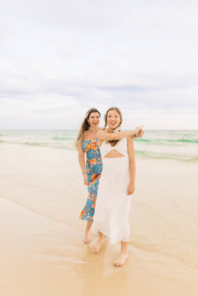 A bride and her best friend dancing on the beach for her bachelorette party.