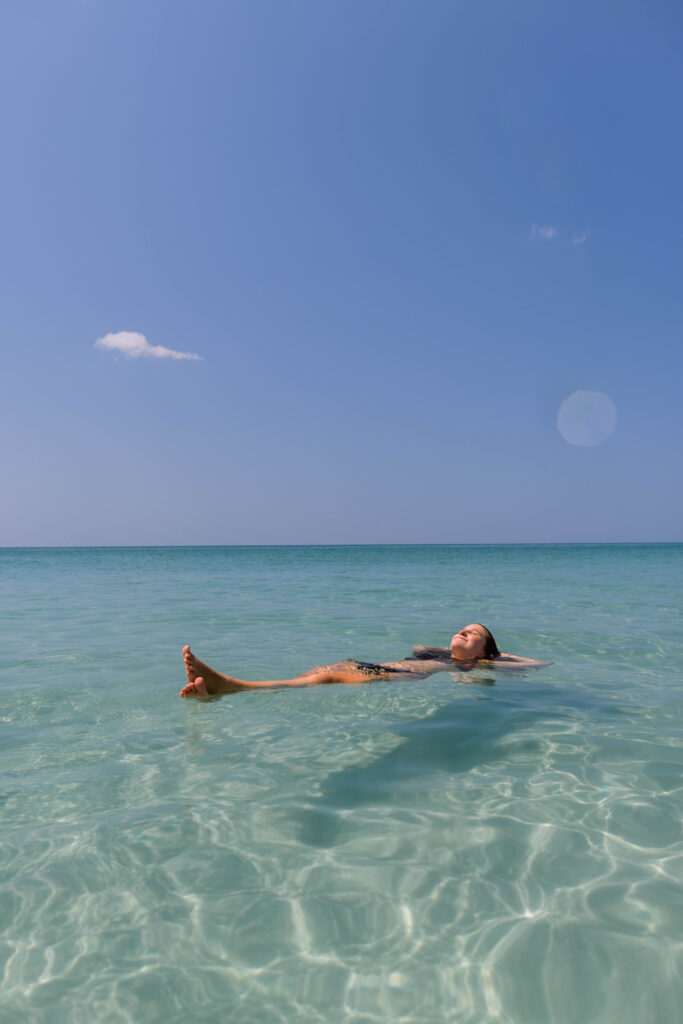 Girl floating in the water on Pensacola beach