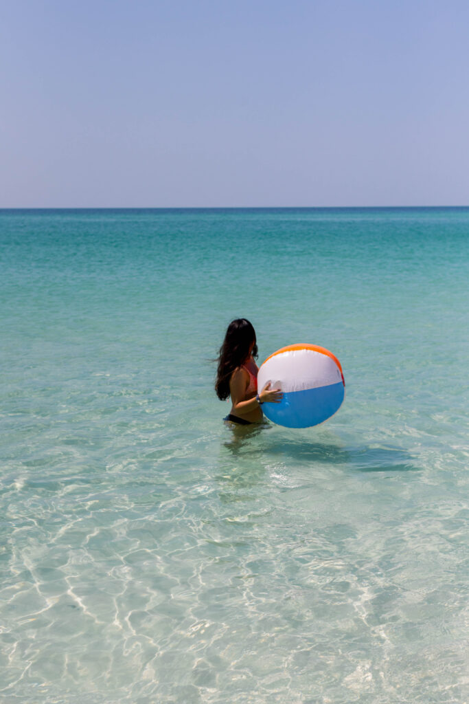 Girl with a beach ball in the water on Pensacola beach