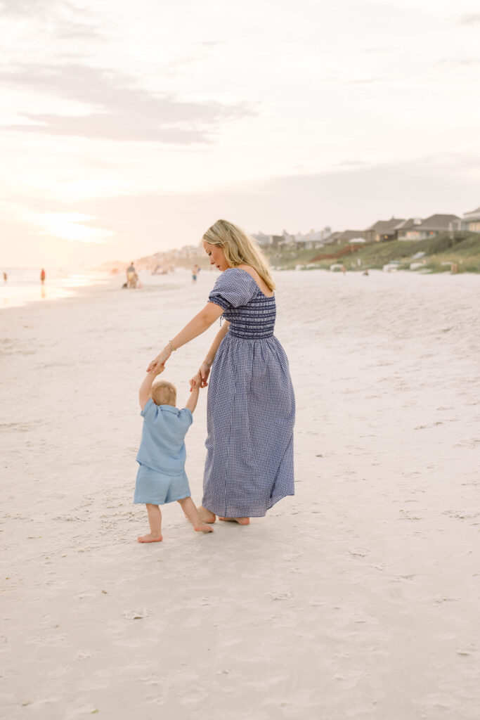 A woman and a baby holding hands on Rosemary Beach
